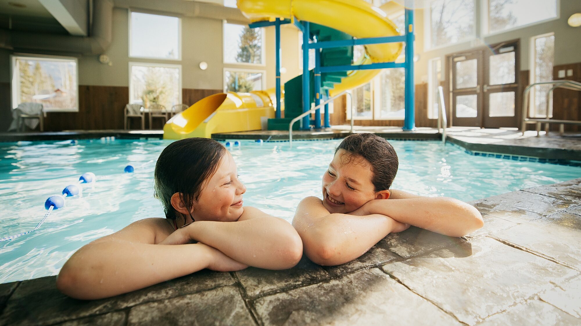 Guests leaning at the pool edge inside the Best Western Plus Valemount indoor pool area