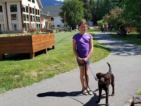 Girl walking dog alongside the trails on property at the Best Western Plus Hotel In Valemount.