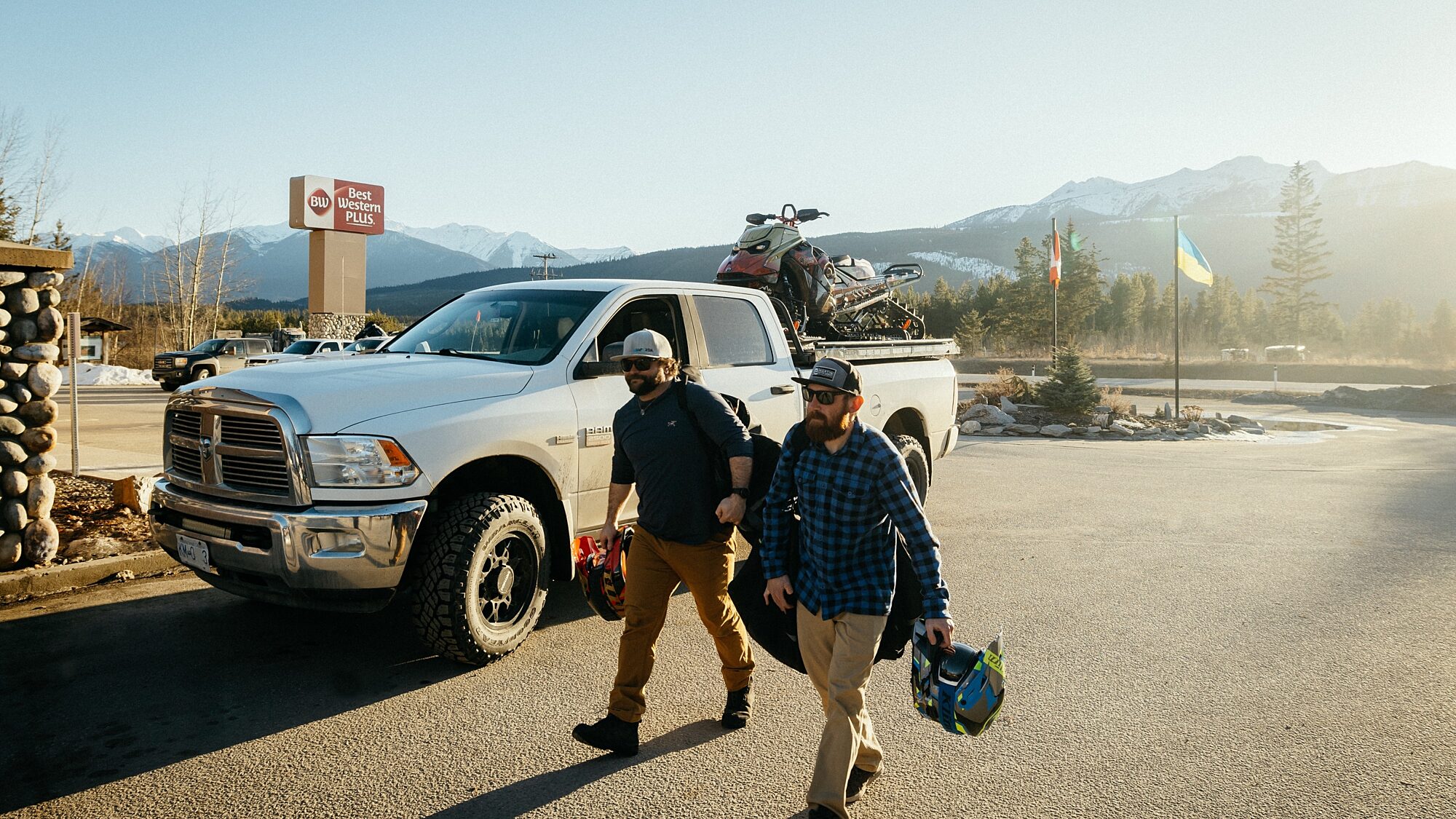 Guests carrying gear while walking along a roadside in a mountain area