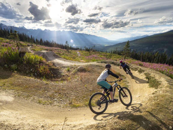 Riders biking along an open trail with mountain views at Varda Mountain
