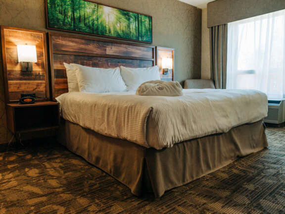 Guest room interior with queen bed and wood-accent headboard