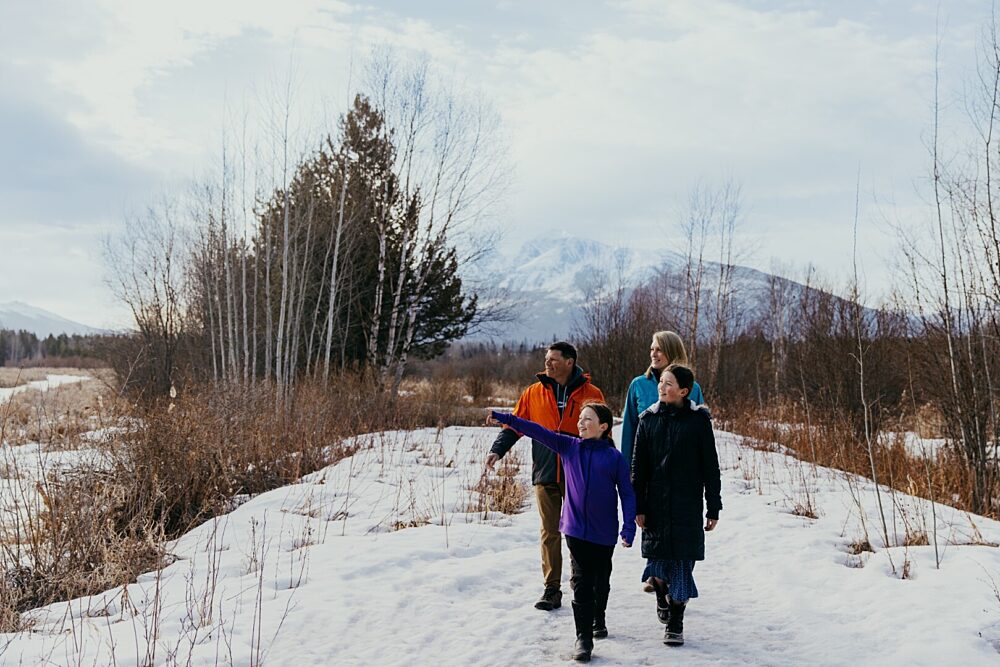 A family enjoys a winter stroll on a sunny day in Cranberry Marsh, just steps away from the Best Western Plus Valemount.