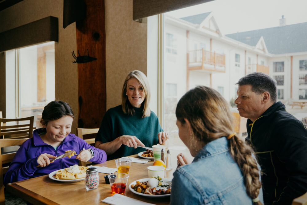 Guest family enjoying breakfast at a table close to a sunny window at the Summit Grill Restaurant on site at the Best Western Plus Valemount