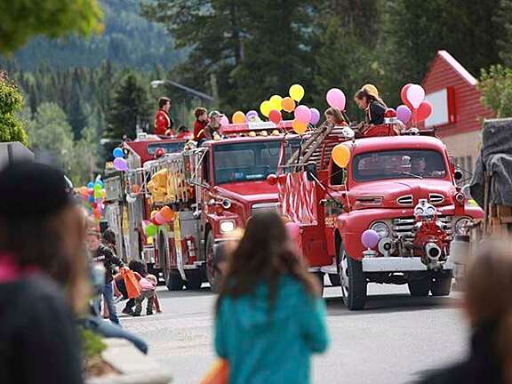 Colorful parade floats and community members celebrating during Valemountain Days in Valemount, BC.