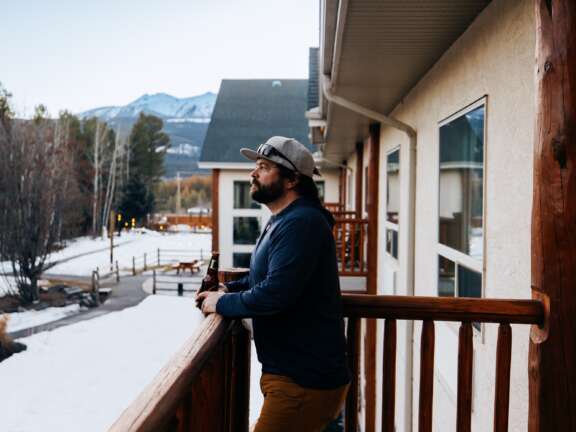 Guest standing on the balcony of an Executive Queen Suite at Best Western Plus Valemount