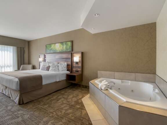 King Suite featuring a king bed and Jacuzzi beside the sleeping area
