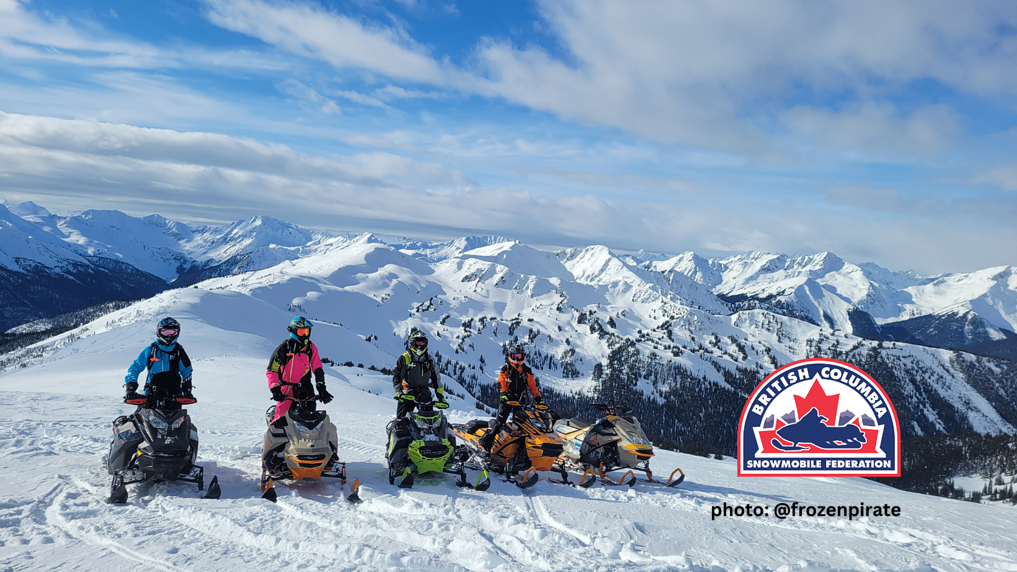 People gathered on motorized sleds at a winter mountain viewpoint